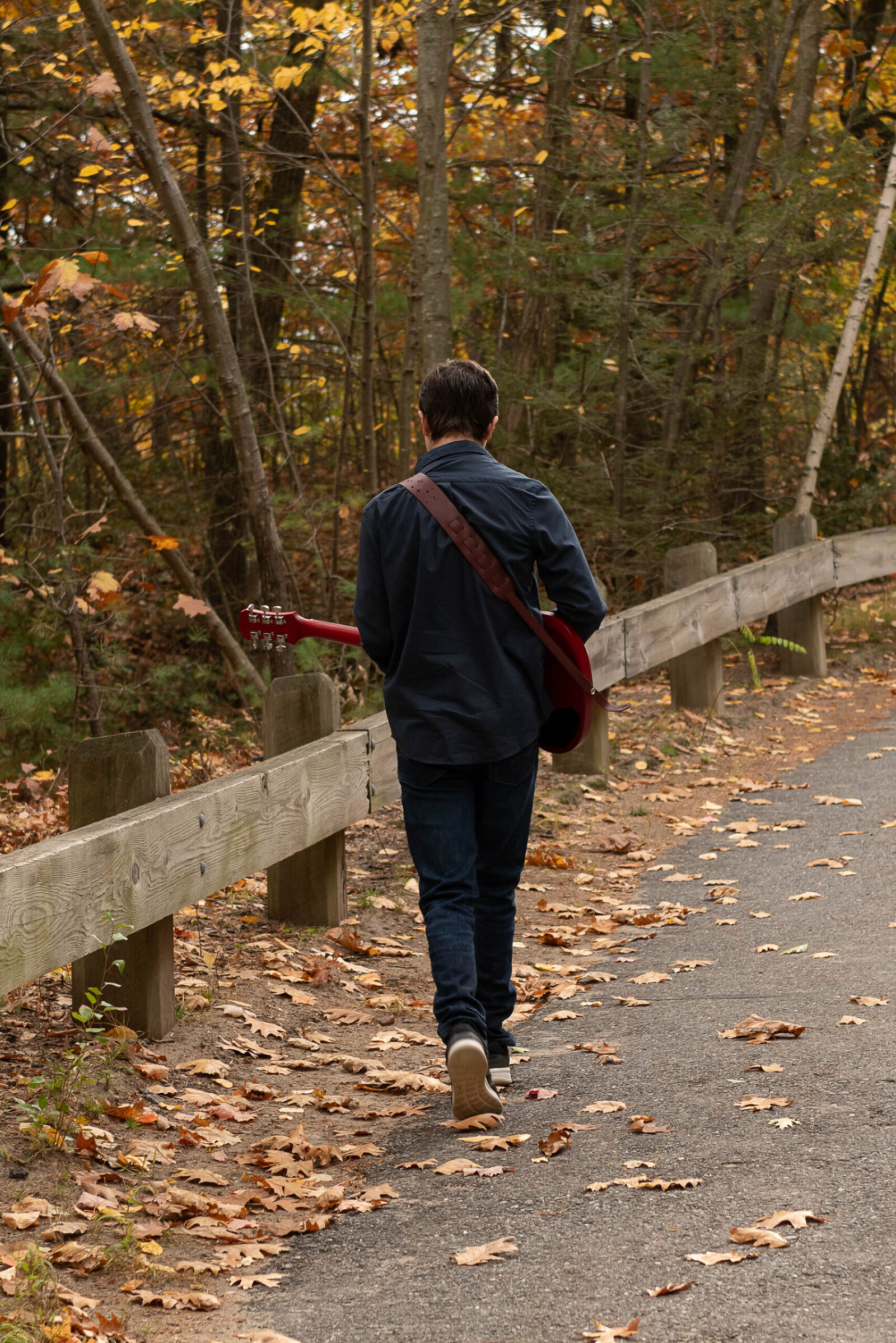 Senior Photo walking away with guitar